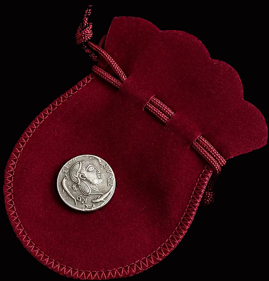 Red velvet pouch with a silver coin on a black background